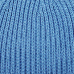 Close-up view of the Isfahan Blue Cashmere Ribbed Short Beanie by William Lockie, displaying a vertical pattern and texture, reminiscent of the luxurious cashmere thread used in their creations.