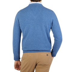 The back view of a man wearing a William Lockie Jeans Blue Lambswool V-Neck Sweater and tan pants.