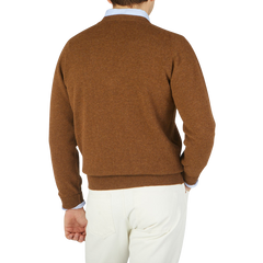 The back view of a man wearing a William Lockie Kestrel Brown Deep V-Neck Lambswool Sweater.