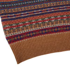 A close up of a Light Brown Fair Isle V-Neck Lambswool Slipover by William Lockie, with a ribbed hem sweater.