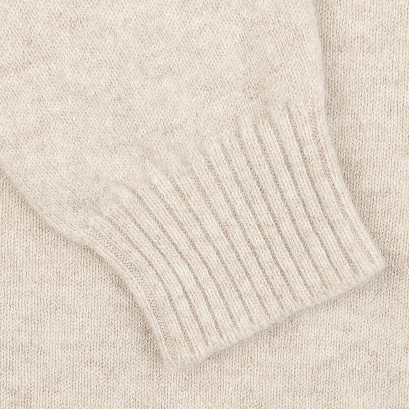 Close-up of the Linen Beige Crew Neck Lambswool Sweater by William Lockie, showcasing the ribbed cuff and textured fabric, meticulously crafted from luxurious Scottish lambswool.