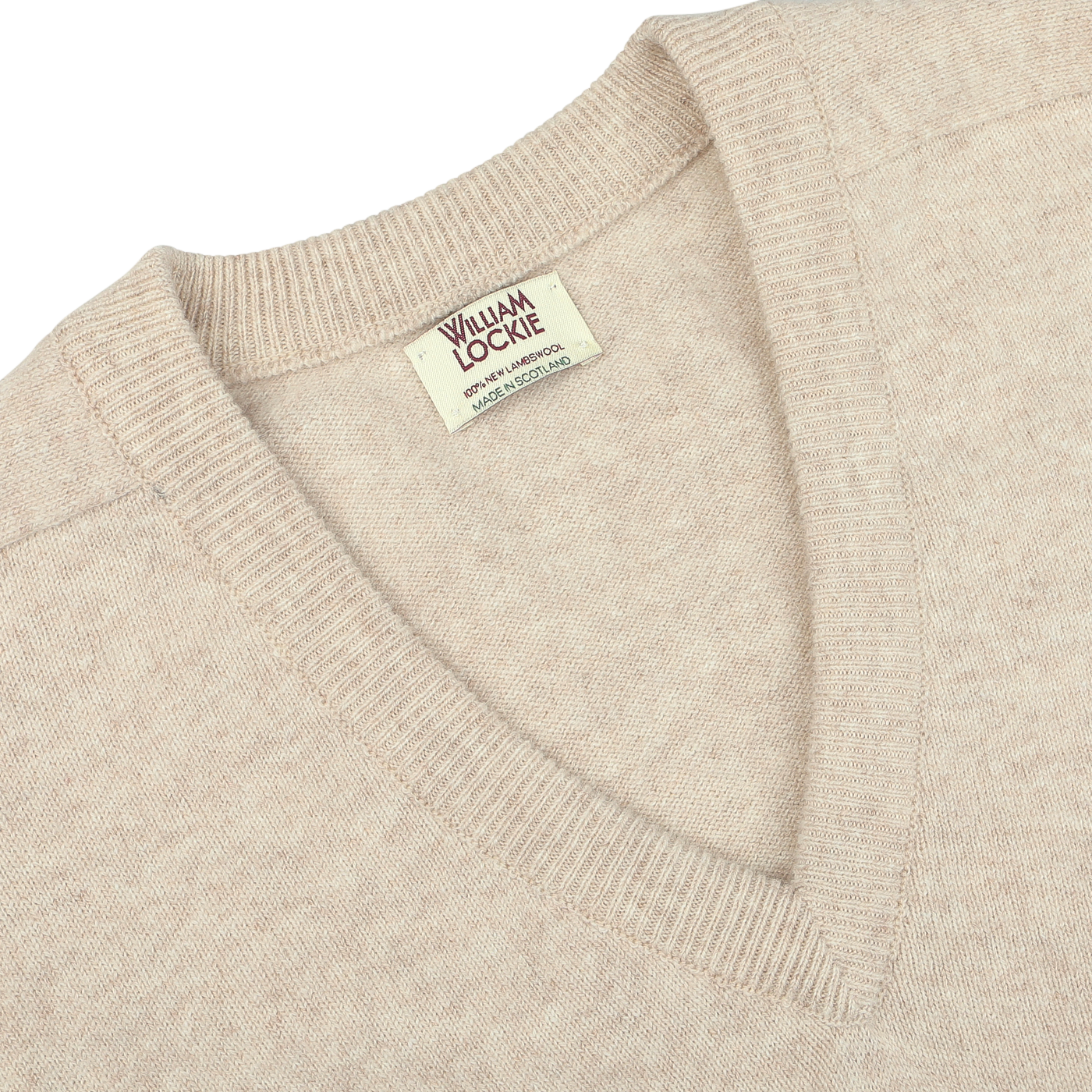 Close-up image of a Linen Beige Deep V-Neck Lambswool Sweater with a label that reads "William Lockie".