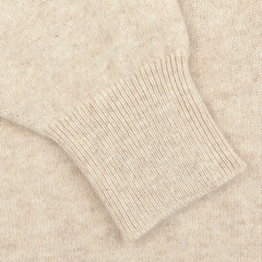 Close-up of a William Lockie Linen Beige Deep V-Neck Lambswool Sweater, showcasing the ribbed cuff detail on its sleeve.