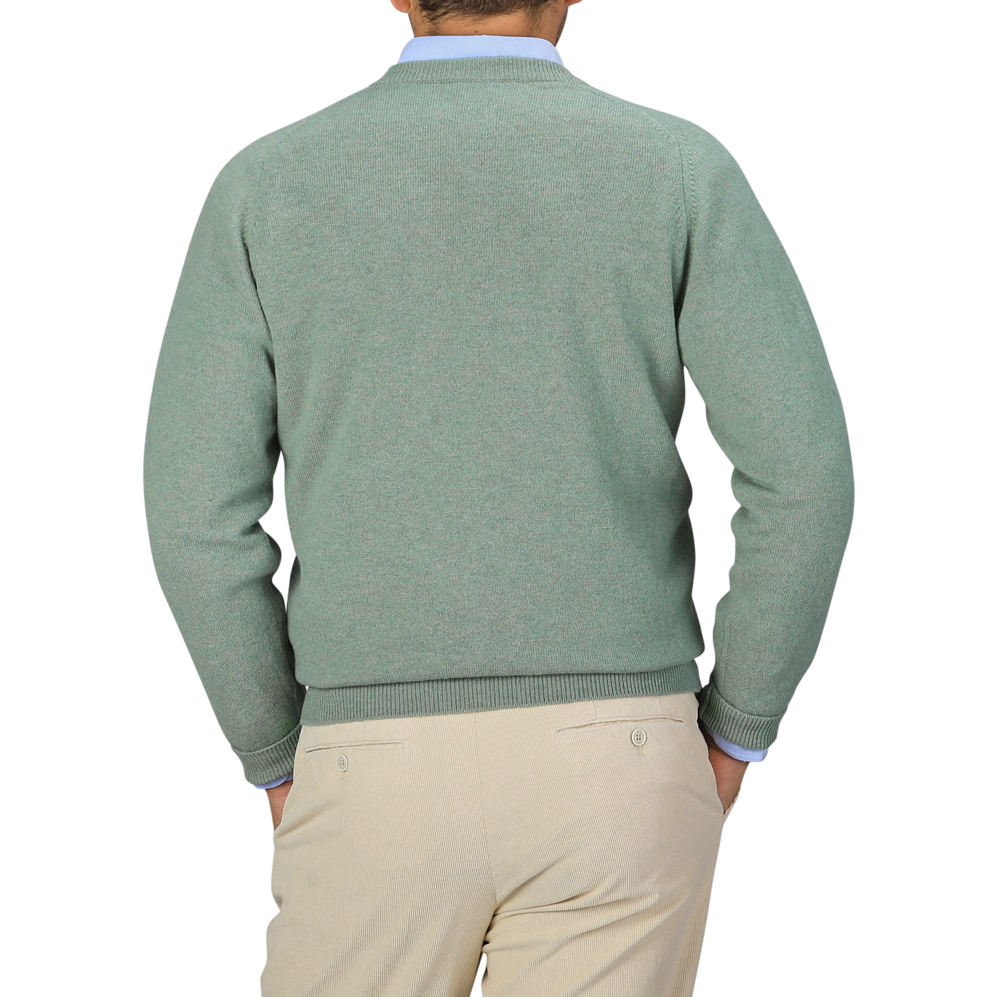 A person is shown from the back, wearing a William Lockie Mojito Green Deep V-Neck Lambswool Sweater and beige trousers.