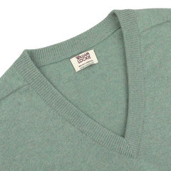 Close-up of a Mojito Green Deep V-Neck Lambswool Sweater with a visible "William Lockie" label near the neckline.