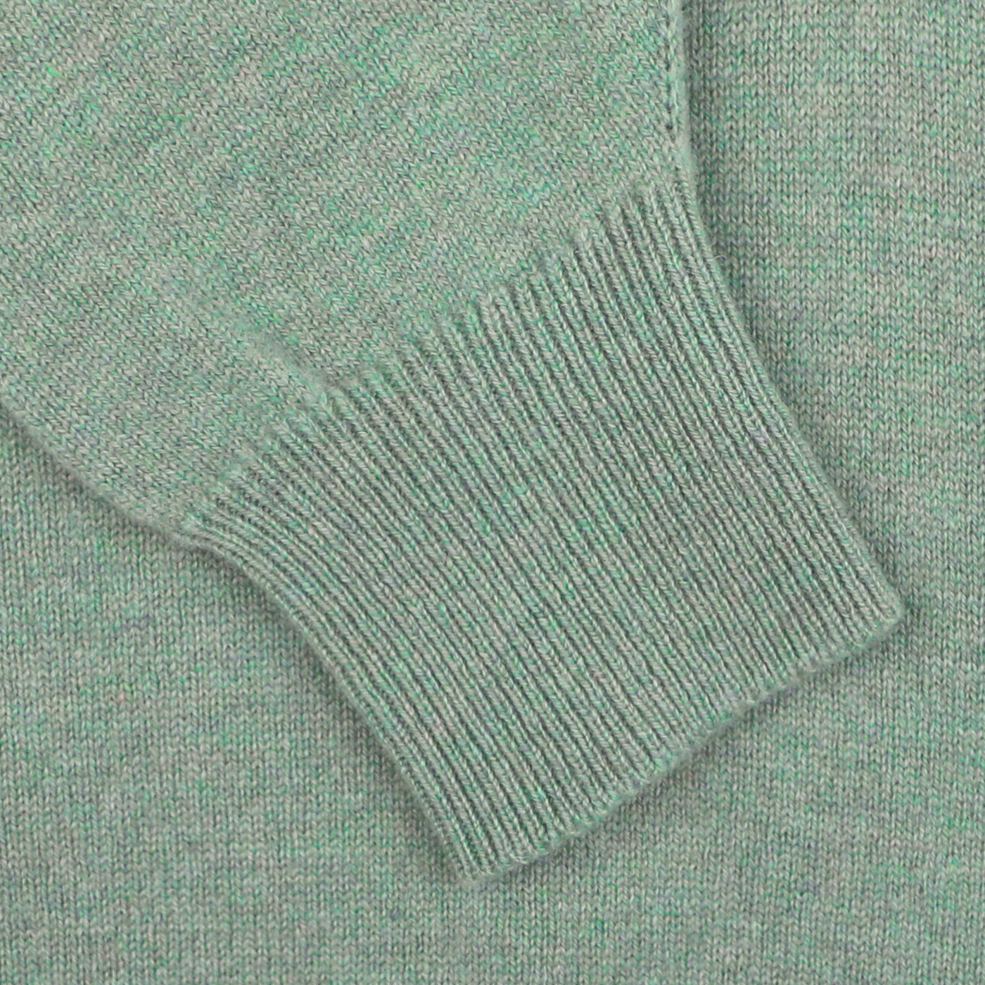 Close-up of the sleeve and cuff of a Mojito Green Deep V-Neck Lambswool Sweater by William Lockie, showcasing the fabric texture and stitching details.