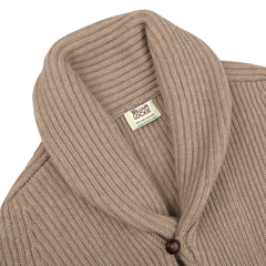 A natural beige cashmere shawl collar cardigan, accentuated by leather buttons, and a "William Lockie" brand label visible inside.