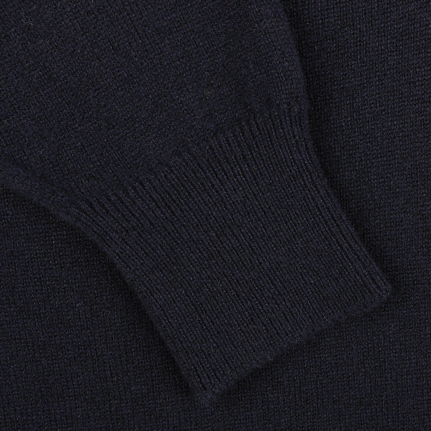 Close-up of a sleeve of the William Lockie Navy Blue Deep V-Neck Lambswool Sweater, showcasing the ribbed cuff detailing.