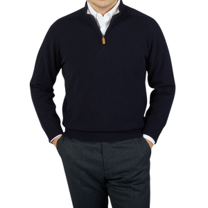 A man wearing a Navy Blue Lambswool 1/4 Sweater by William Lockie and gray pants.