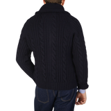 The back view of a man wearing a William Lockie Navy Cable-Knit Lambswool Shawl Collar Cardigan.