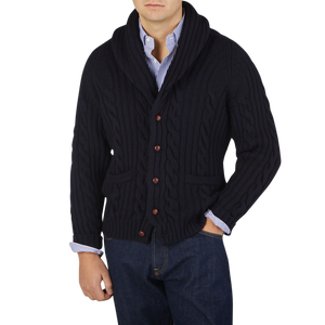 A man wearing a Navy Cable-Knit Lambswool Shawl Collar Cardigan by William Lockie.