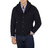 A man wearing a Navy Cable-Knit Lambswool Shawl Collar Cardigan by William Lockie.