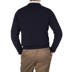 The back view of a man wearing a William Lockie Navy Crew Neck Cashmere Sweater and tan pants.