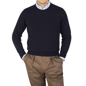 A man wearing a William Lockie Scottish Navy Crew Neck Cashmere Sweater and brown pants.