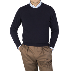 A man wearing a William Lockie Scottish Navy Crew Neck Cashmere Sweater and brown pants.