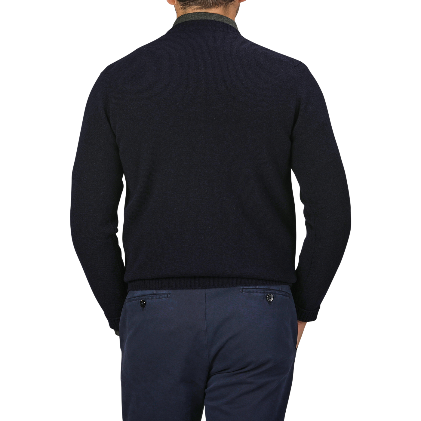 A person wearing a William Lockie Navy Crewneck Lambswool Sweater and blue pants is shown from the back, epitomizing a smart casual look. The background is gray.