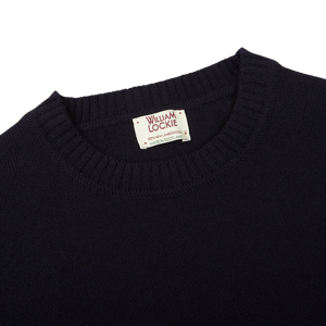 A Navy Crewneck Lambswool Sweater with a William Lockie label on it, perfect for layering.