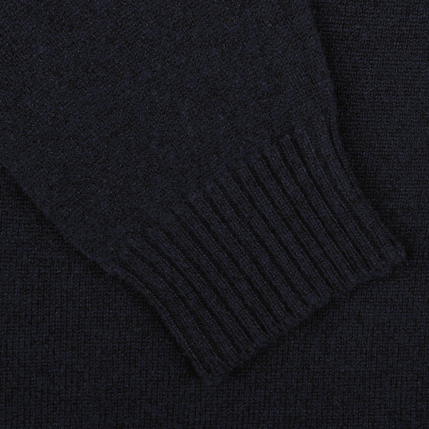 Detailed look at the William Lockie Navy Crewneck Lambswool Sweater, featuring dark-colored knitted fabric with ribbed cuffs, ideal for a smart casual style.