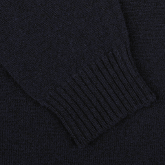 Detailed look at the William Lockie Navy Crewneck Lambswool Sweater, featuring dark-colored knitted fabric with ribbed cuffs, ideal for a smart casual style.