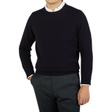 A man donning a William Lockie Navy Crewneck Lambswool Sweater.