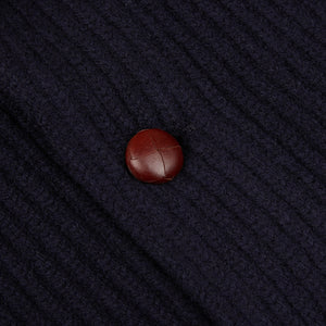 A close up of a William Lockie Navy Lambswool Shawl Collar Cardigan with a brown button.