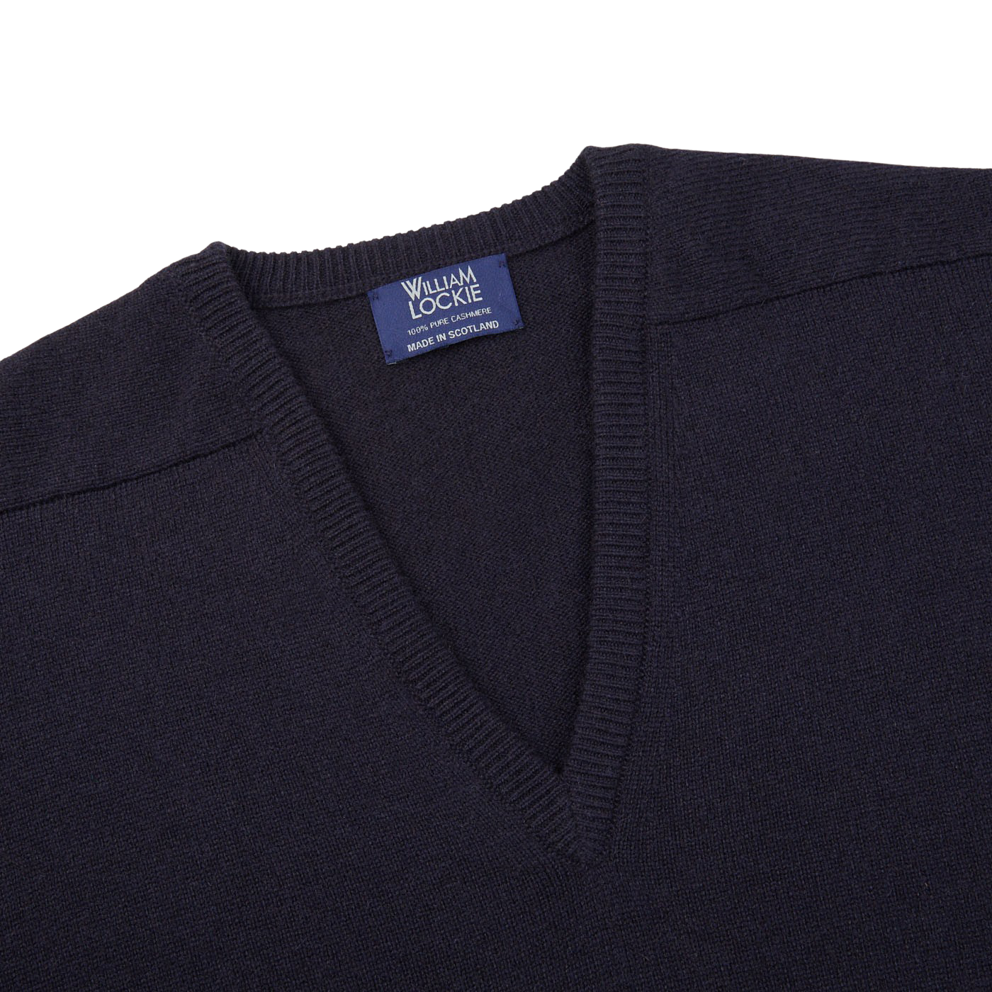 The William Lockie navy v-neck cashmere sweater, made from luxurious Scottish cashmere, is shown on a white background with its ribbed hems prominently displayed.