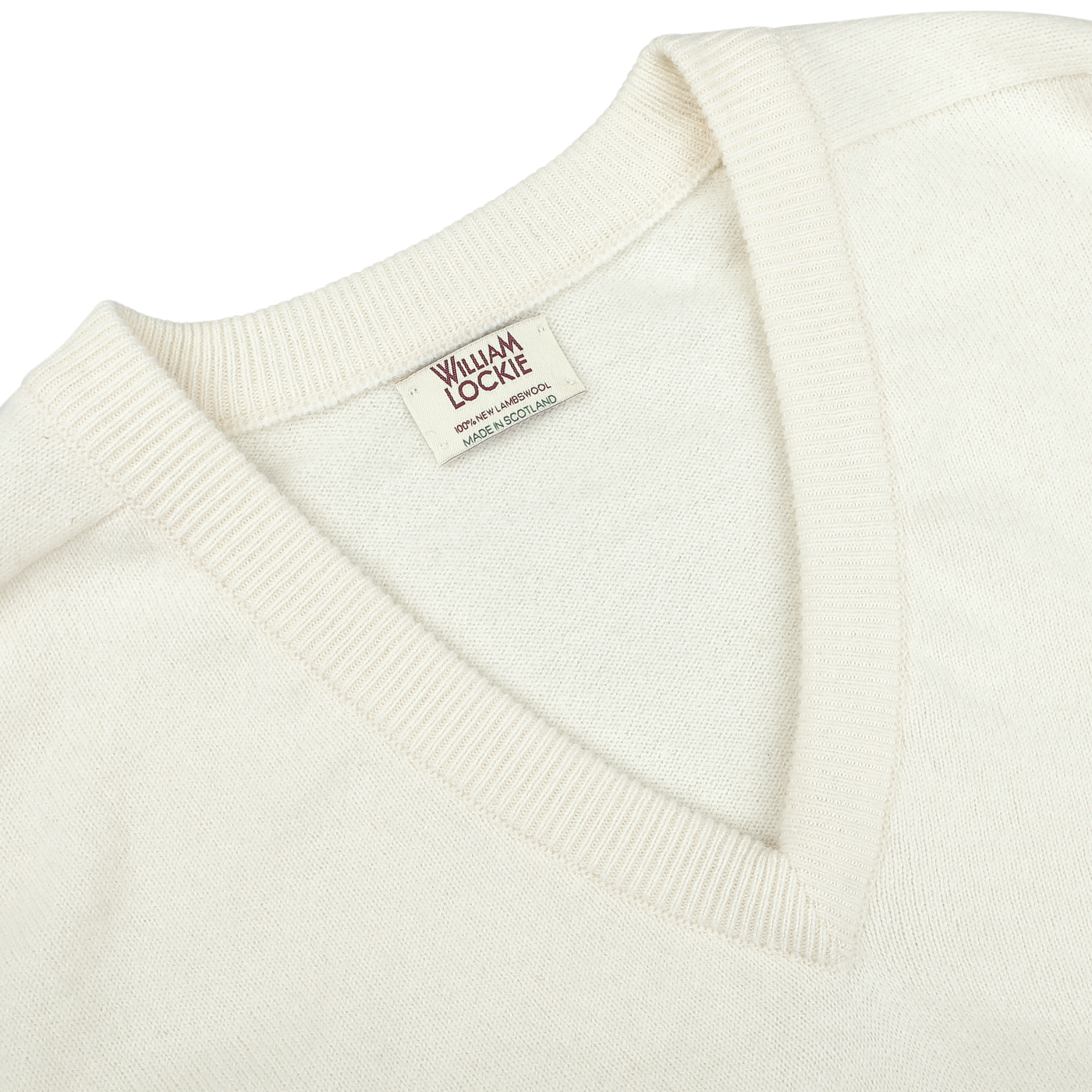 A close-up of an Off-White Deep V-Neck Lambswool Sweater with a visible clothing label reading "William Lockie.