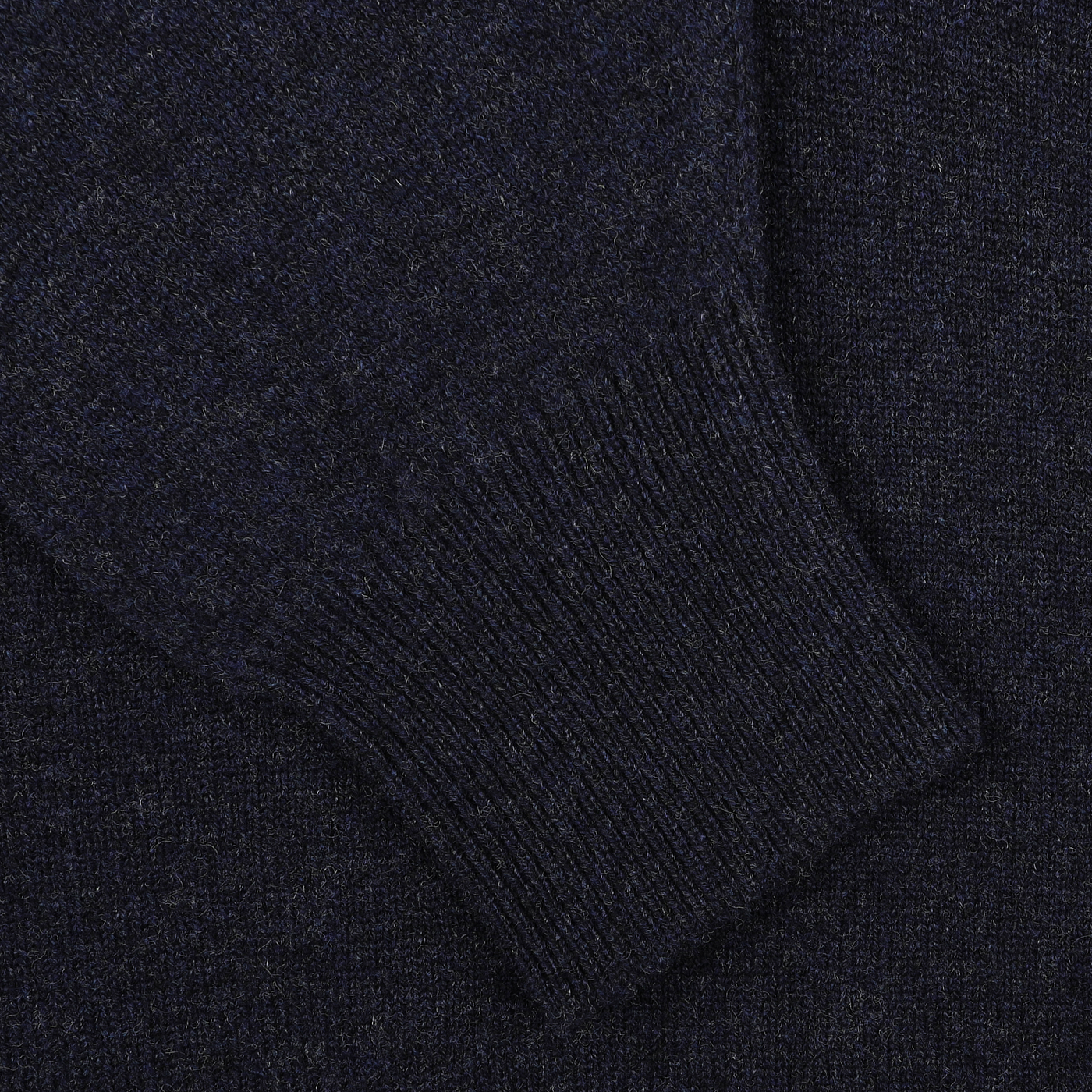 Close-up of the sleeve of a William Lockie Oxford Blue Deep V-Neck Lambswool Sweater, showcasing the ribbed cuff detail and texture.