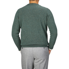 A person wearing a Peacock Crew Neck Lambswool Sweater by William Lockie and gray pants is shown from the back against a plain background.