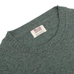 A close-up of a Peacock Crew Neck Lambswool Sweater made from soft Scottish lambswool, featuring a William Lockie brand label.