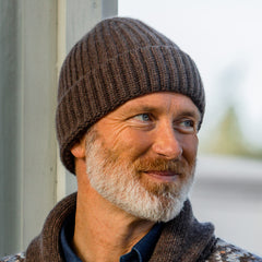 A man wearing a Cocoa Geelong Lambswool Ribbed Beanie by William Lockie.