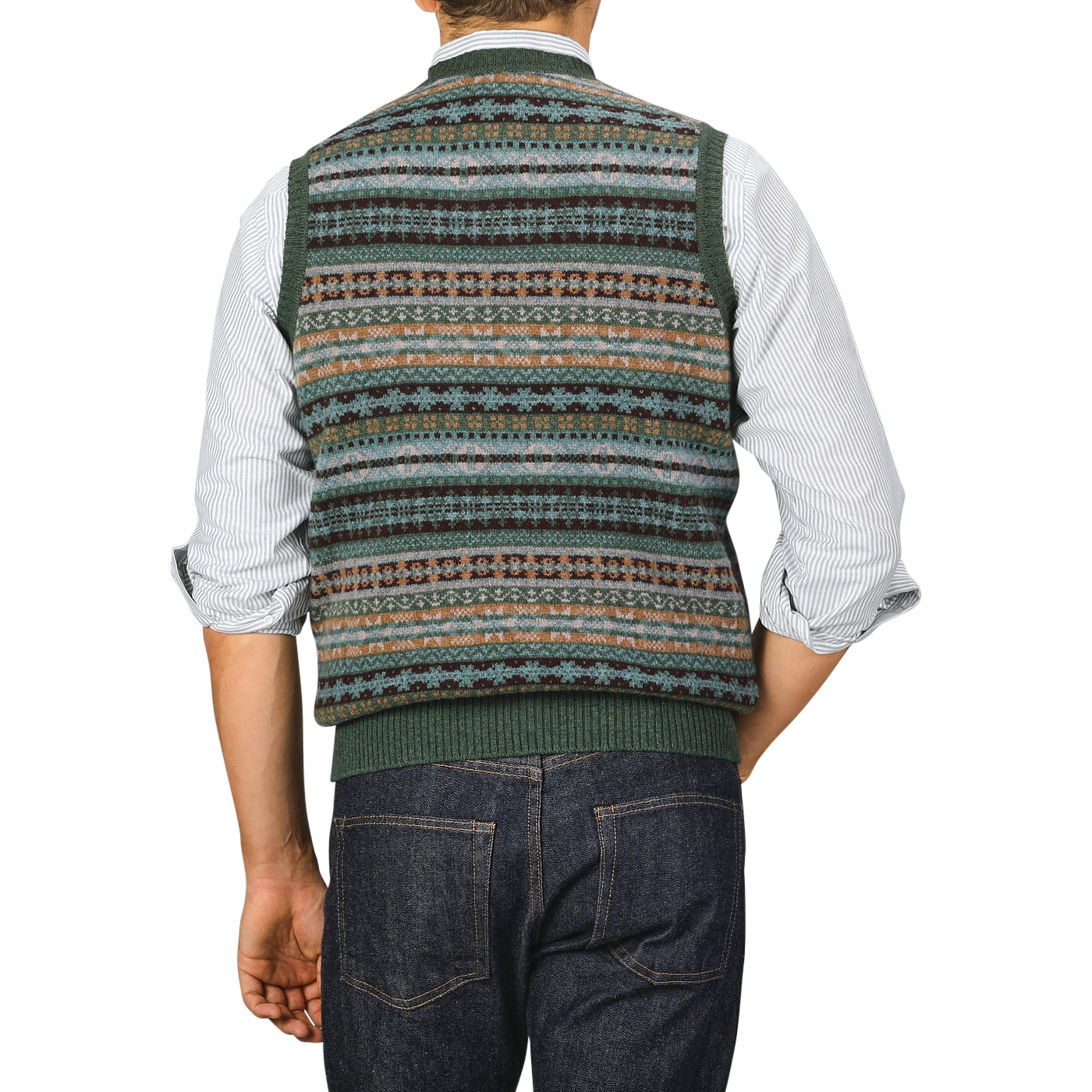 A man wearing a William Lockie Rosemary Green Fair Isle V-Neck Lambswool Slipover over a striped shirt and dark jeans, viewed from the back.