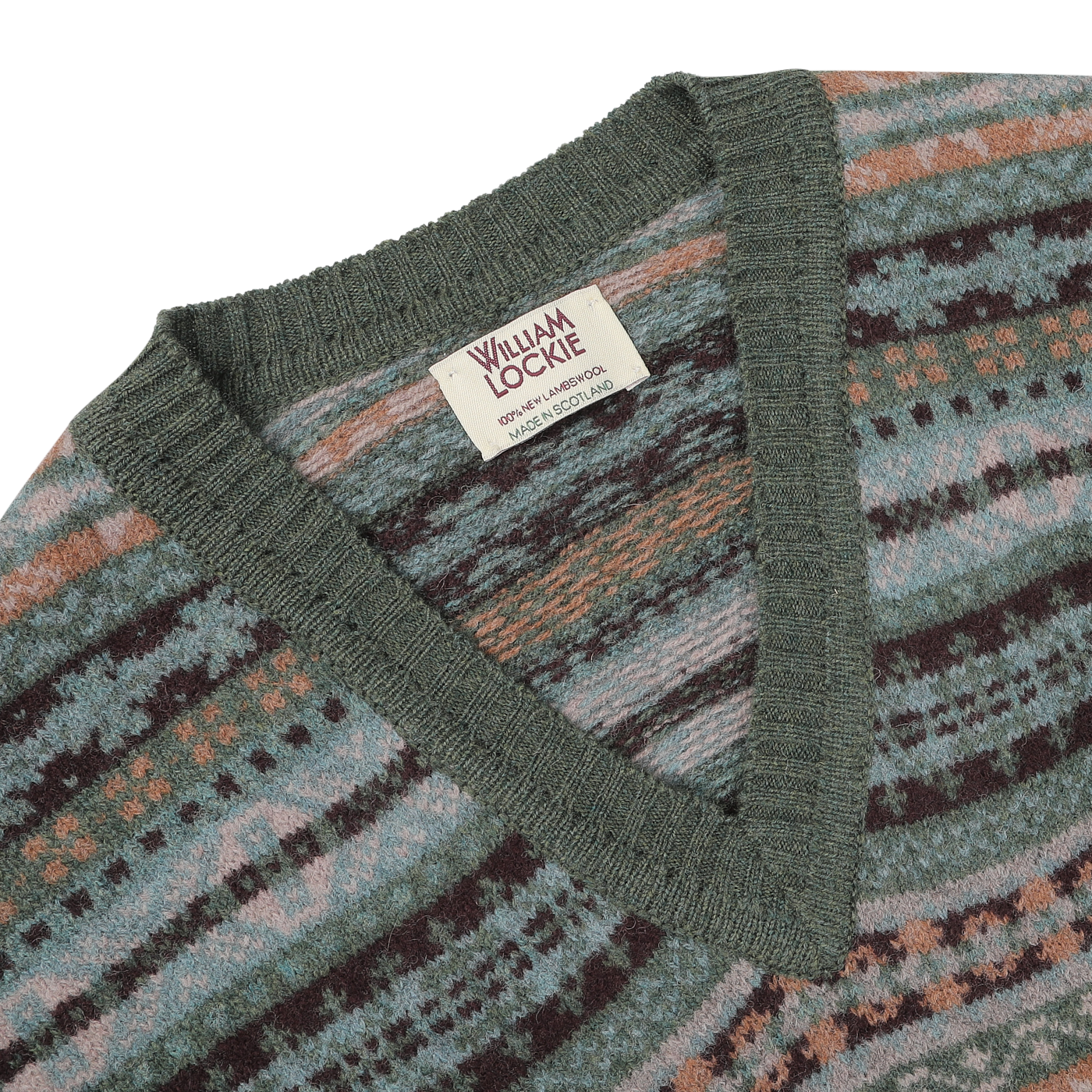 A close-up of the Rosemary Green Fair Isle V-Neck Lambswool Slipover, crafted from soft Scottish lambswool, features a label that reads "William Lockie Made in Scotland.