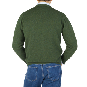 The back view of a man wearing a William Lockie Rosemary Green Lambswool Saddle Shoulder Cardigan.