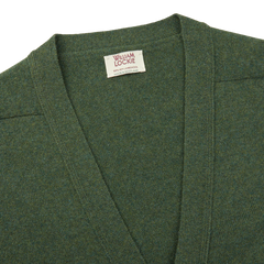 A William Lockie Rosemary Green Lambswool Saddle Shoulder Cardigan with a label on it, perfect for layering.