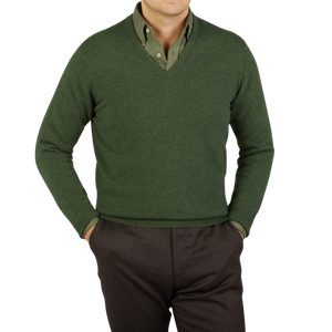 A man wearing a Rosemary Green V-Neck Lambswool Sweater by William Lockie for warmth.