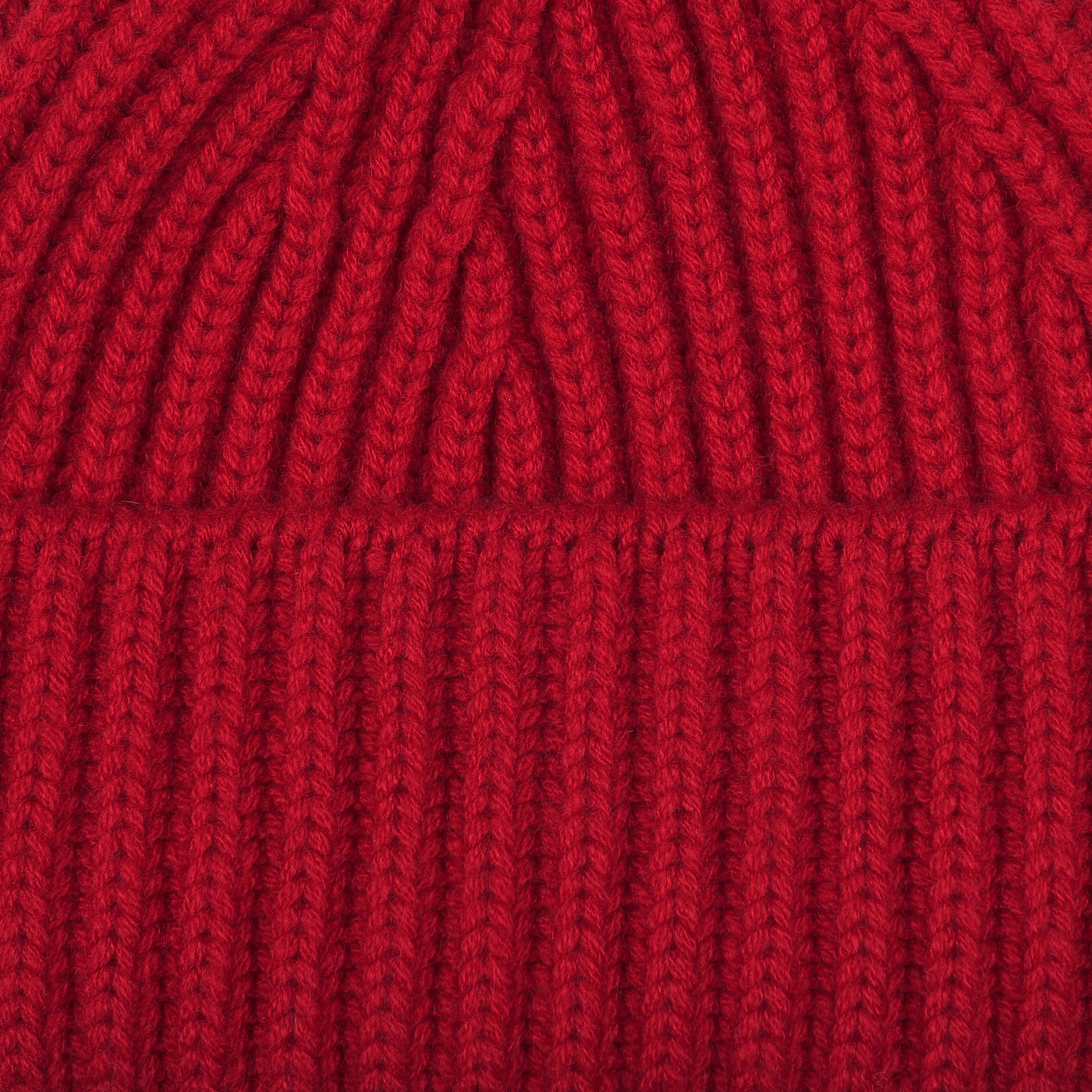 Close-up of the Ruby Red Cashmere Short Ribbed Beanie, highlighting the detailed ribbing texture characteristic of William Lockie's chunky cashmere designs.