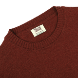 Close-up view of a Sienna Brown Crew Neck Lambswool Sweater with a William Lockie label sewn into the neckline, showcasing premium Scottish lambswool.