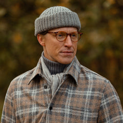 A man wearing a William Lockie Smog Grey Cashmere Ribbed Short Beanie.