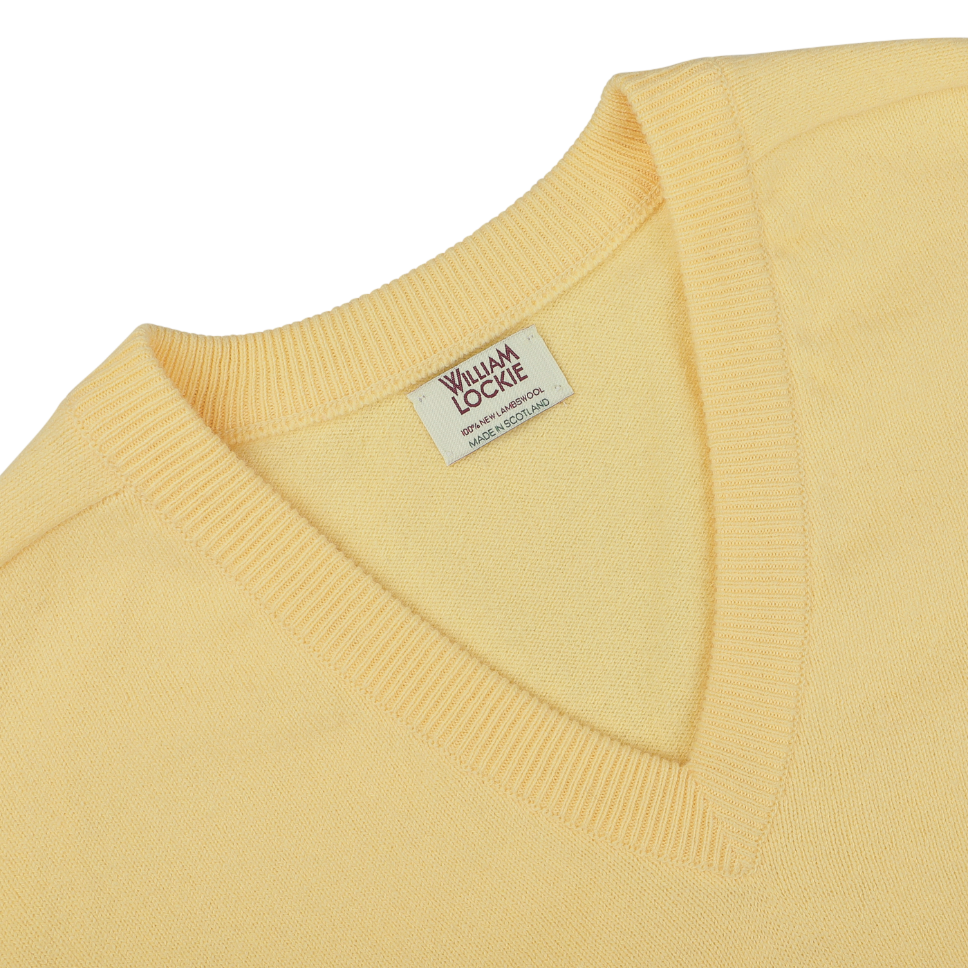 Close-up of a Solar Yellow Deep V-Neck Lambswool Sweater with a visible "William Lockie" label inside the collar.