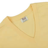 Close-up of a Solar Yellow Deep V-Neck Lambswool Sweater with a visible "William Lockie" label inside the collar.