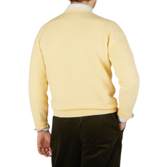 The back view of a man wearing a William Lockie Solar Yellow Lambswool Saddle Shoulder Cardigan.