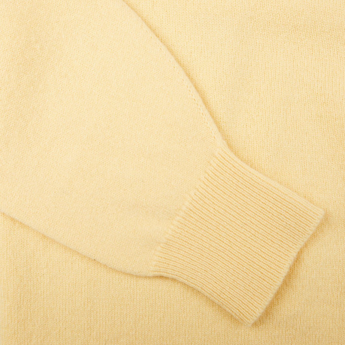 A close up of a Solar Yellow Lambswool Saddle Shoulder Cardigan made with Scottish lambswool by William Lockie.