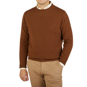 A man wearing a warm William Lockie Spaniel Brown Crew Neck Lambswool Sweater.