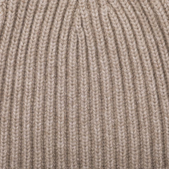 Close-up view of the Stoneage Beige Cashmere Ribbed Short Beanie by William Lockie, showcasing the intricate knitted fabric with its chunky cashmere thread pattern.