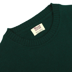 The Tartan Green Crew Neck Lambswool Sweater by William Lockie, crafted from Scottish lambswool, features ribbed details and a visible label for an extra touch of warmth.