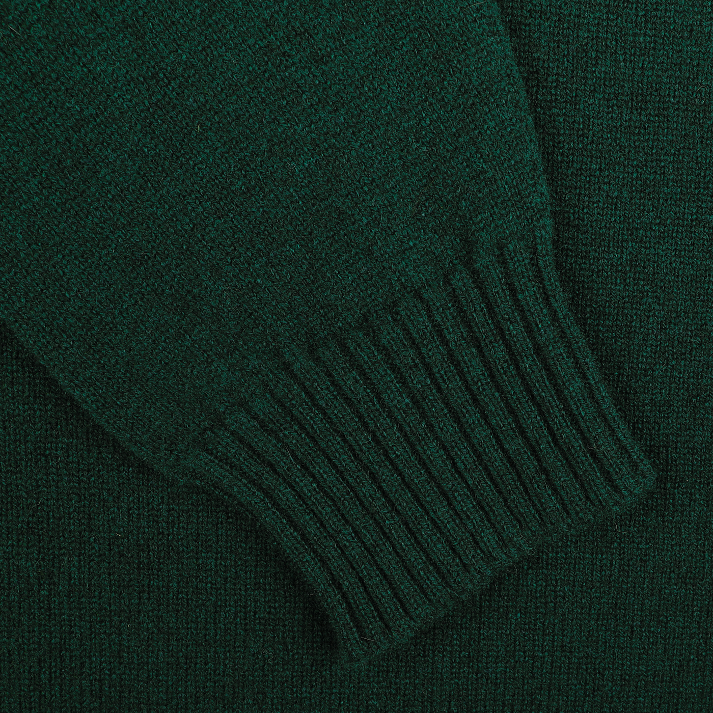 Close-up of the Tartan Green Crew Neck Lambswool Sweater sleeve showing the ribbed cuff and texture of the fabric, made from luxurious Scottish lambswool by William Lockie for extra warmth.