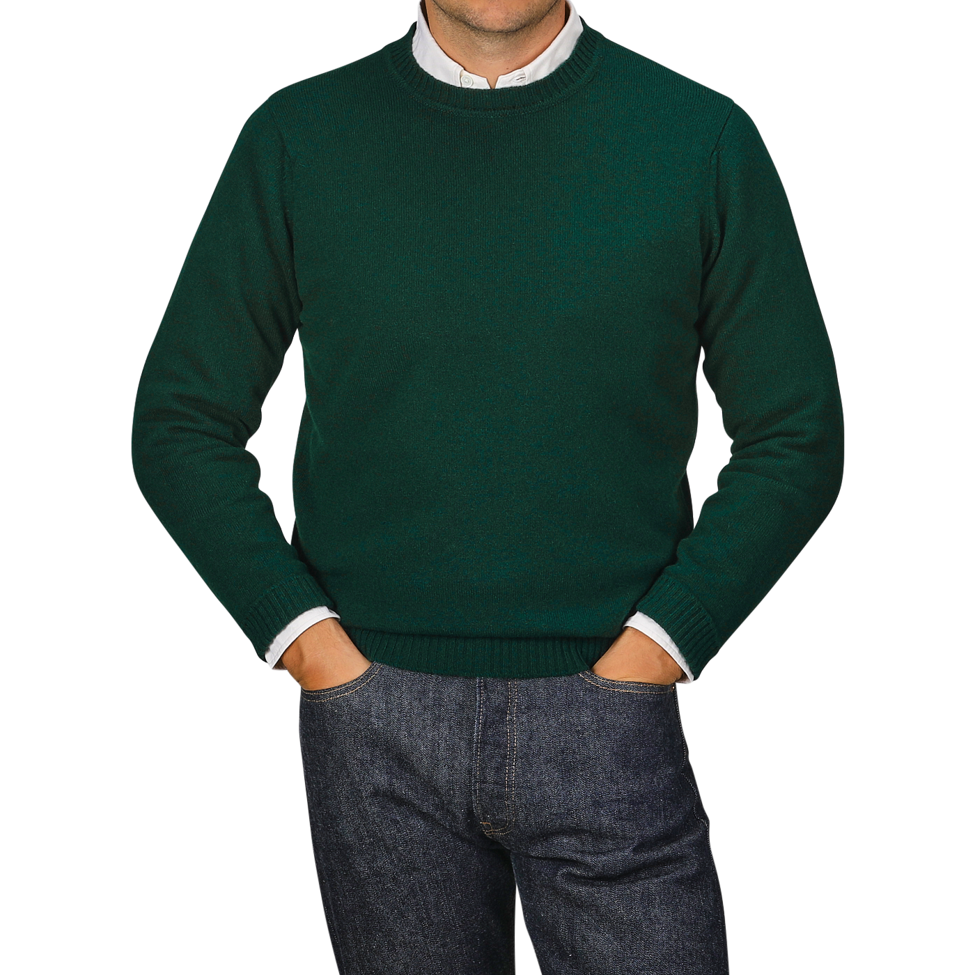 A person in a Tartan Green Crew Neck Lambswool Sweater from William Lockie and blue jeans stands with their hands in their pockets. The face is not visible.