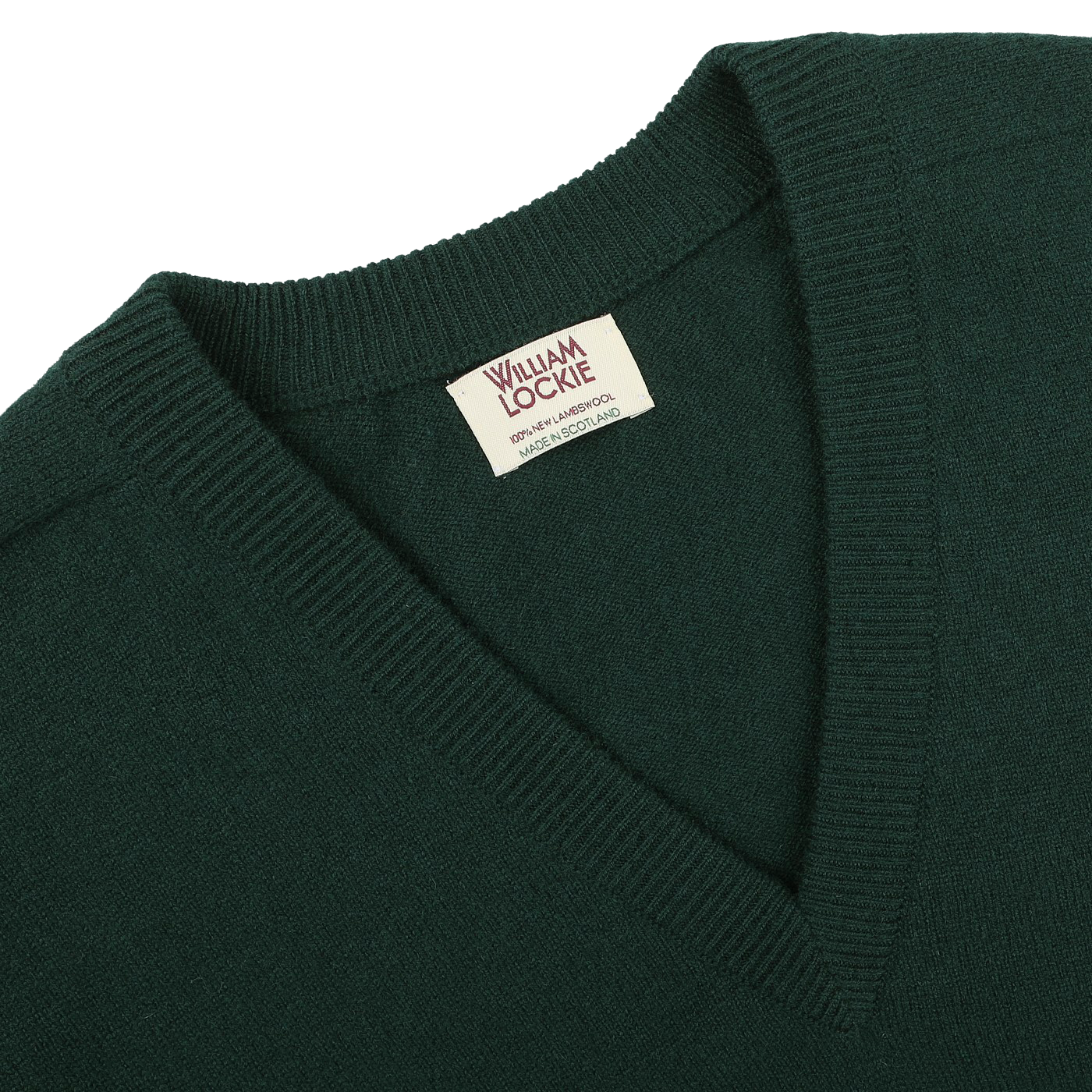 Close-up of a tartan green deep V-neck lambswool sweater, showcasing a tag that reads "William Lockie" and "Made in Scotland.