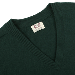 Close-up of a tartan green deep V-neck lambswool sweater, showcasing a tag that reads "William Lockie" and "Made in Scotland.